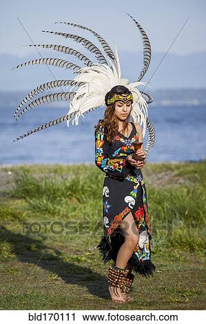 Stock Image - Native American woman in traditional headdress performing ceremony. Fotosearch