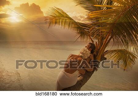 Older Caucasian couple hugging on palm tree at beach View Large Photo Image Stock Image - Older Caucasian couple hugging on palm tree at beach. Fotosearch