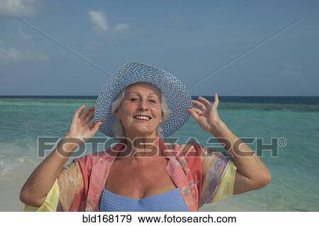 Older Caucasian woman smiling on beach View Large Photo Image Stock Photo - Older Caucasian woman smiling on beach. Fotosearch