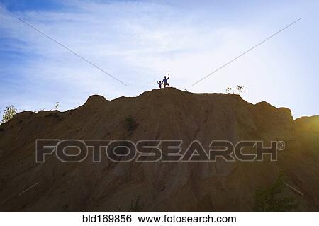 People standing on hilltop under blue sky View Large Photo Image Stock Photograph - People standing on hilltop under blue sky. Fotosearch