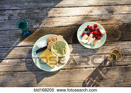 Plates of cheese and fruit on wooden table View Large Photo Image Stock Photography - Plates of cheese and fruit on wooden table. Fotosearch