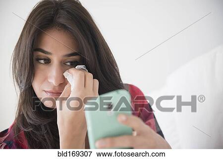 Sad woman crying and using cell phone View Large Photo Image Stock Photo - Sad woman crying and using cell phone. Fotosearch