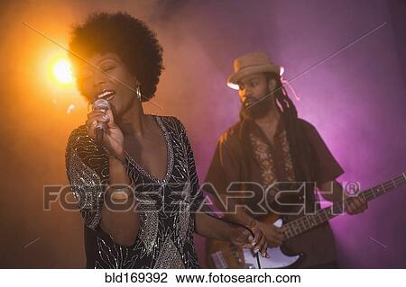 Stock Image - Singer and guitarist performing on stage. Fotosearch