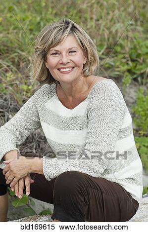 Smiling Caucasian woman sitting on beach View Large Photo Image Stock Photography - Smiling Caucasian woman sitting on beach. Fotosearch