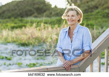 Smiling Caucasian woman standing on beach View Large Photo Image Stock Image - Smiling Caucasian woman standing on beach. Fotosearch