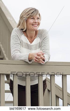 Smiling Caucasian woman standing staircase banister View Large Photo Image Stock Photo - Smiling Caucasian woman standing staircase banister. Fotosearch