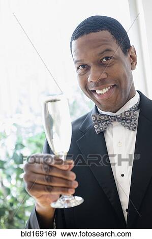 Stock Photo - Smiling groom toasting with champagne. Fotosearch