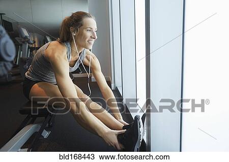 Smiling woman stretching in gym View Large Photo Image Stock Image - Smiling woman stretching in gym. Fotosearch