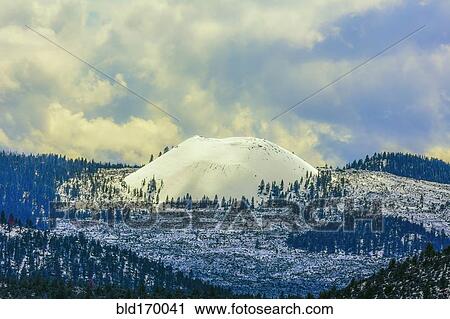Stock Image - Snowy mountains under clouds. Fotosearch