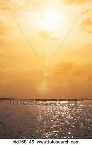 Stock Photography - Sunset over rippling ocean water. Fotosearch