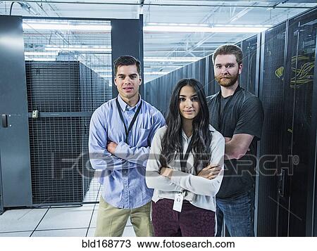 Stock Image - Technicians smiling in server room. Fotosearch