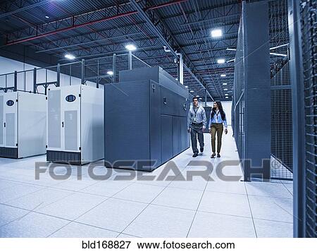 Technicians walking in server room View Large Photo Image Stock Photo - Technicians walking in server room. Fotosearch