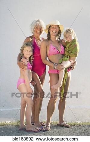 Stock Image - Three generations of Caucasian women smiling on beach. Fotosearch