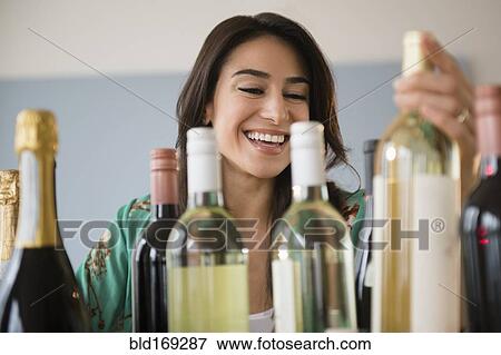 Stock Photo - Woman choosing bottle of wine. Fotosearch