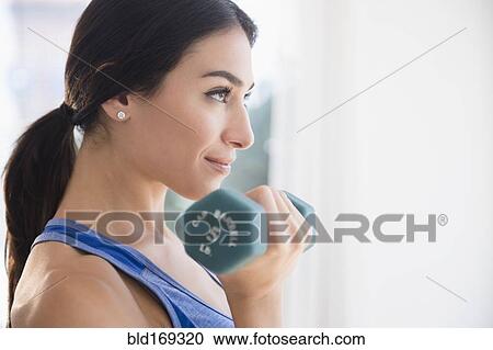 Stock Image - Woman lifting weights. Fotosearch