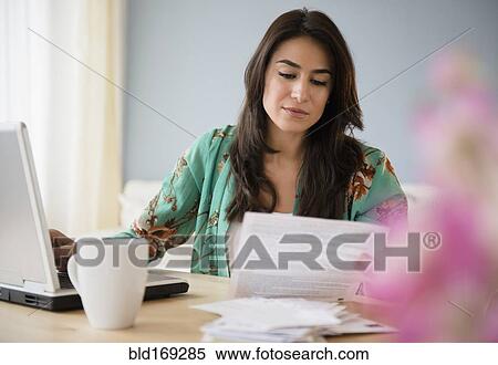 Stock Photography - Woman paying bills on laptop. Fotosearch