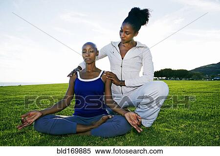 Woman practicing yoga with teacher in park View Large Photo Image Stock Photography - Woman practicing yoga with teacher in park. Fotosearch