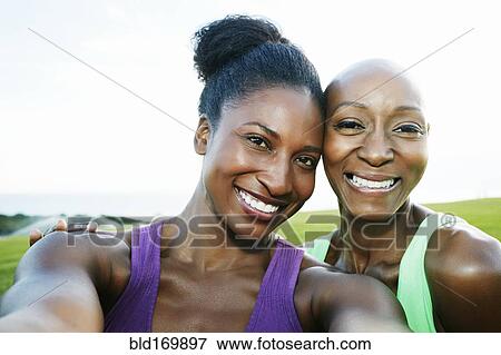 Stock Photo - Women smiling in park. Fotosearch