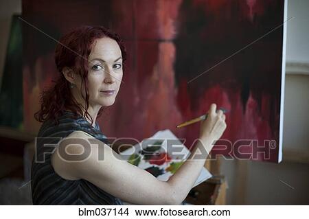 Picture - Artist painting on canvas in studio. Fotosearch