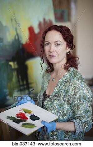 Stock Image - Artist painting on canvas in studio. Fotosearch