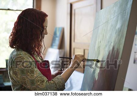 Stock Photo - Artist painting on canvas in studio. Fotosearch