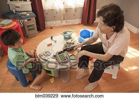 Asian grandmother and grandson playing at table View Large Photo Image Stock Photo - Asian grandmother and grandson playing at table. Fotosearch