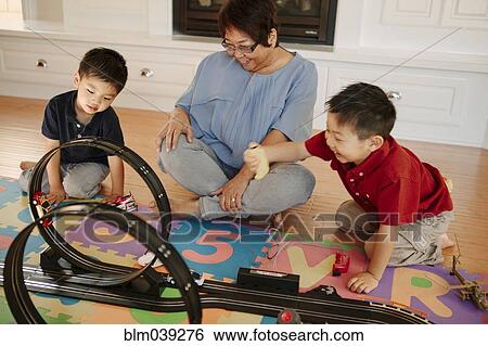 Stock Photograph - Asian grandmother playing with grandsons. Fotosearch