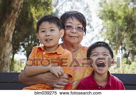 Asian grandmother sitting with grandsons on bench View Large Photo Image Stock Photography - Asian grandmother sitting with grandsons on bench. Fotosearch