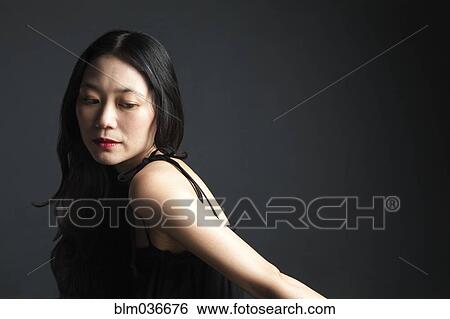 Asian woman looking over her shoulder View Large Photo Image Stock Photograph - Asian woman looking over her shoulder. Fotosearch