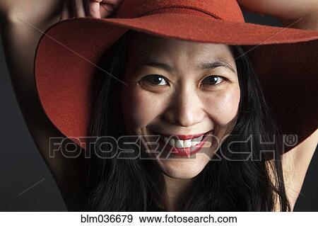 Asian woman smiling in red hat View Large Photo Image Stock Photo - Asian woman smiling in red hat. Fotosearch