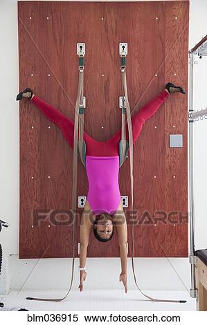 Stock Photography - Asian woman using exercise equipment in gymnasium. Fotosearch
