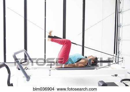 Asian woman using exercise machine in gymnasium View Large Photo Image Picture - Asian woman using exercise machine in gymnasium. Fotosearch