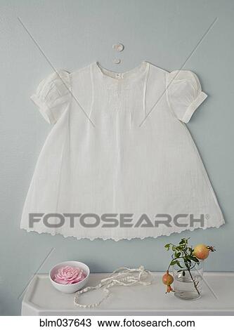 Baby dress over flowers on counter View Large Photo Image Stock Image - Baby dress over flowers on counter. Fotosearch