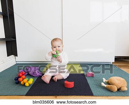 Baby girl playing with toys on carpet View Large Photo Image Stock Photograph - Baby girl playing with toys on carpet. Fotosearch