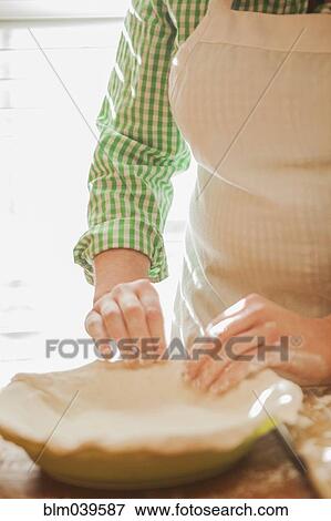 Baker pressing pie dough in dish View Large Photo Image Stock Photo - Baker pressing pie dough in dish. Fotosearch