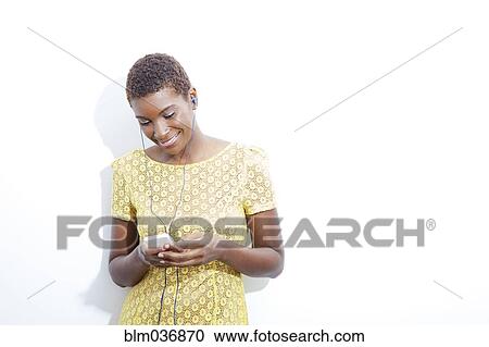 Stock Image - Black woman listening to mp3 player. Fotosearch