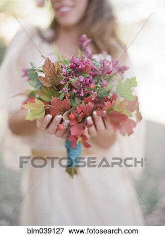Stock Photo - Bride holding bouquet of flowers. Fotosearch