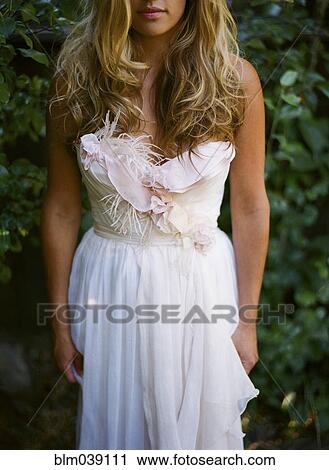 Bride wearing wedding dress in garden View Large Photo Image Stock Image - Bride wearing wedding dress in garden. Fotosearch
