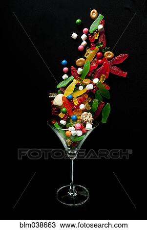 Stock Image - Candy falling into cocktail glass. Fotosearch