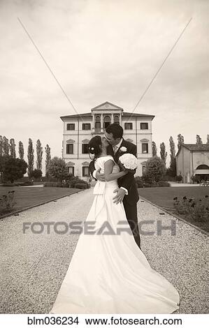 Caucasian bride and groom kissing on gravel path View Large Photo Image Picture - Caucasian bride and groom kissing on gravel path. Fotosearch
