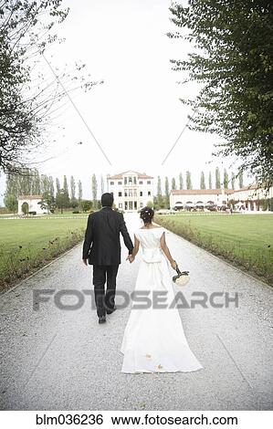 Caucasian bride and groom walking on gravel path View Large Photo Image Stock Photograph - Caucasian bride and groom walking on gravel path. Fotosearch