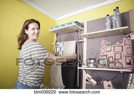 Caucasian business owner arranging items in store View Large Photo Image Stock Image - Caucasian business owner arranging items in store. Fotosearch