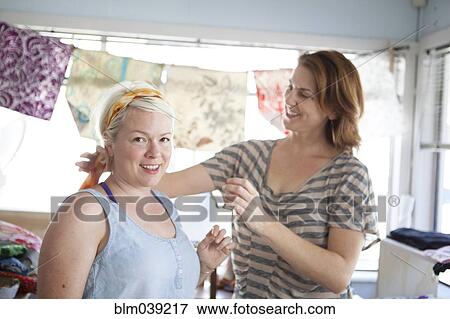 Caucasian business owner assisting customer with headscarf View Large Photo Image Stock Photo - Caucasian business owner assisting customer with headscarf. Fotosearch