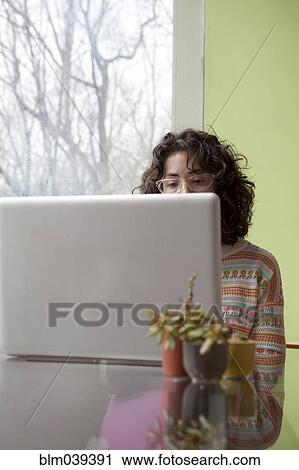 Stock Image - Caucasian businesswoman using laptop at desk. Fotosearch