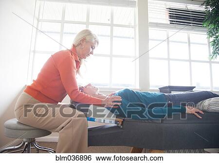 Caucasian chiropractor massaging shoulders of client View Large Photo Image Stock Photograph - Caucasian chiropractor massaging shoulders of client. Fotosearch