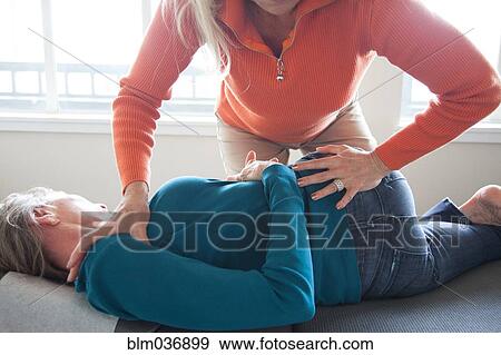 Caucasian chiropractor stretching back of client View Large Photo Image Stock Photo - Caucasian chiropractor stretching back of client. Fotosearch