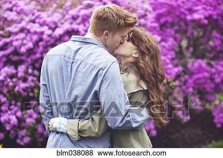 Stock Photo - Caucasian couple kissing in park. Fotosearch