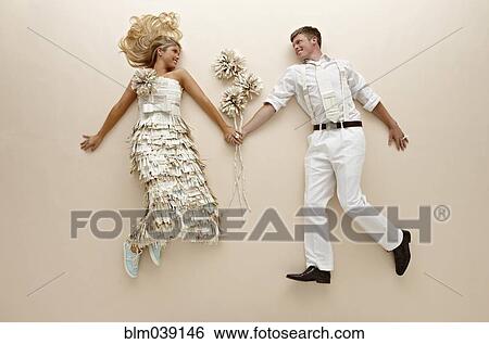 Caucasian couple with flowers laying on floor View Large Photo Image Stock Photograph - Caucasian couple with flowers laying on floor. Fotosearch