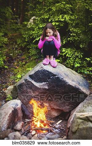 Stock Photo - Caucasian girl admiring campfire. Fotosearch