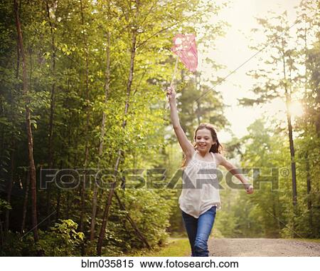 Stock Photography - Caucasian girl carrying butterfly net. Fotosearch